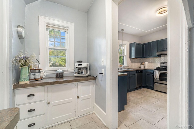 8123 E Lafayette St, Detroit, MI 48214 - kitchen with stainless steel appliances, light tile patterned flooring, under cabinet range hood, and plenty of natural light