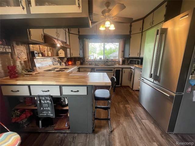1264 Brabbs St, Burton, MI 48509 - kitchen featuring stainless steel appliances, under cabinet range hood, dark wood-style floors, ceiling fan, and a peninsula