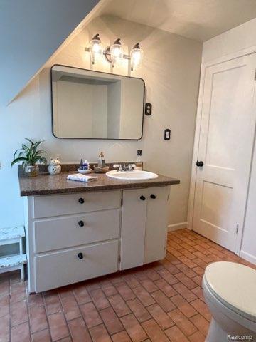 1264 Brabbs St, Burton, MI 48509 - bathroom featuring vanity, brick patterned flooring, toilet, and baseboards