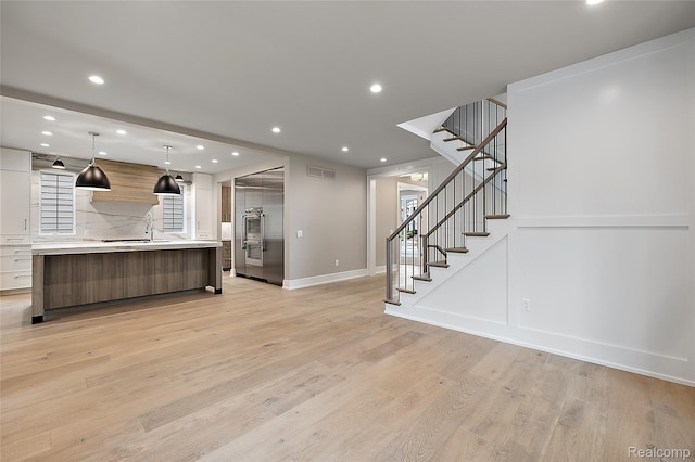 1626 Maryland Blvd, Birmingham, MI 48009 - kitchen featuring modern cabinets, open floor plan, light countertops, a large island with sink, and light wood finished floors