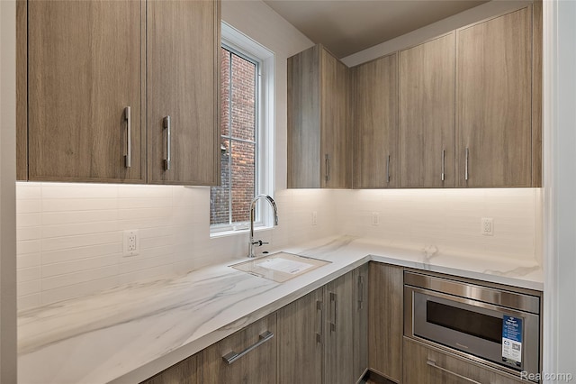 1626 Maryland Blvd, Birmingham, MI 48009 - kitchen featuring stainless steel microwave, a sink, tasteful backsplash, and light stone countertops