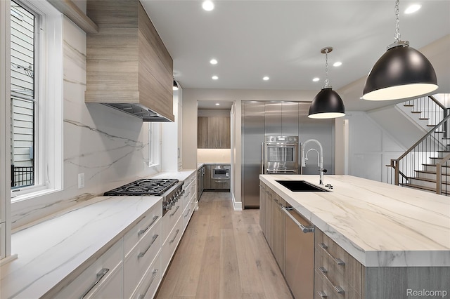 1626 Maryland Blvd, Birmingham, MI 48009 - kitchen featuring appliances with stainless steel finishes, a sink, light wood-type flooring, a large island with sink, and custom range hood