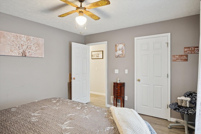 113 Diversy Dr, Brooklyn, MI 49230 - bedroom featuring light wood-style floors, ceiling fan, baseboards, and a textured ceiling