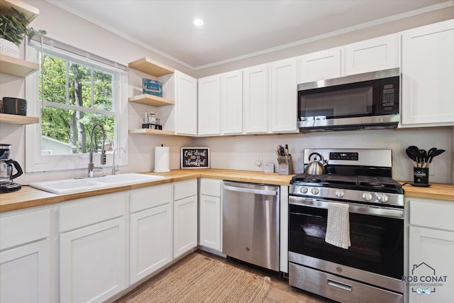18335 Oakland Dr, New Buffalo, MI 49117 - kitchen featuring stainless steel appliances, butcher block counters, open shelves, white cabinetry, and a sink