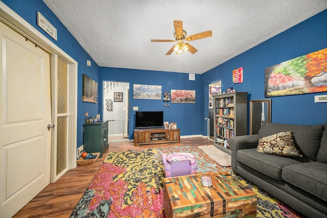 114 Orange St, Jackson, MI 49202 - living room with wood finished floors, ceiling fan, a textured ceiling, and baseboards
