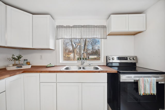 1585 Leeds Ave, Benton Harbor, MI 49022 - kitchen featuring stainless steel electric stove, a sink, butcher block counters, and white cabinets