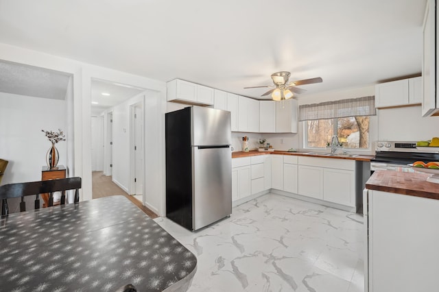 1585 Leeds Ave, Benton Harbor, MI 49022 - kitchen with appliances with stainless steel finishes, wooden counters, a sink, ceiling fan, and light marble finish flooring