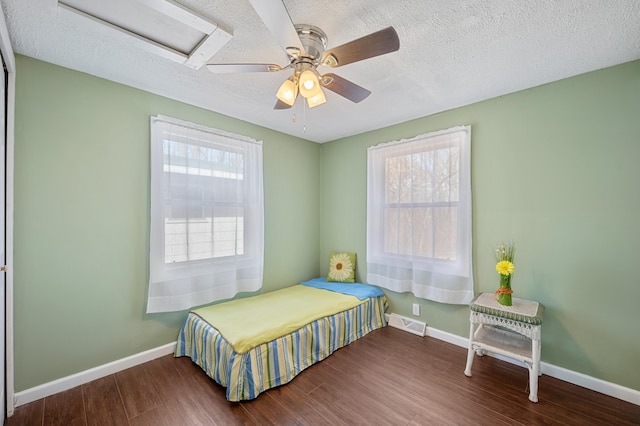 1585 Leeds Ave, Benton Harbor, MI 49022 - bedroom with wood finished floors, multiple windows, a textured ceiling, and baseboards
