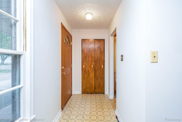 2548 Hearthside Dr, Ypsilanti, MI 48198 - hallway featuring light floors, baseboards, and a textured ceiling