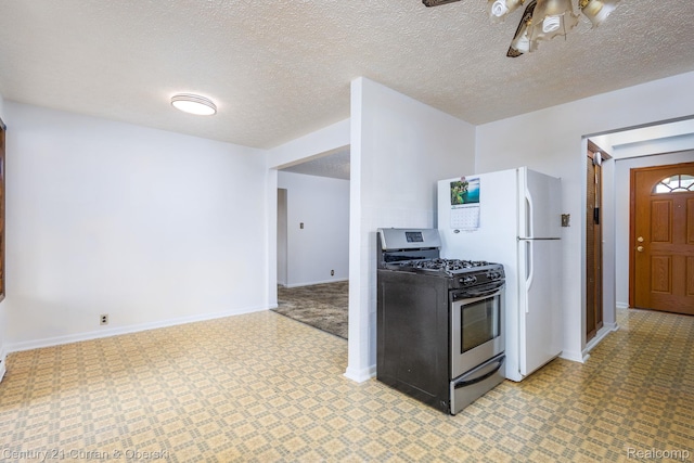 2548 Hearthside Dr, Ypsilanti, MI 48198 - kitchen with gas stove, baseboards, freestanding refrigerator, a textured ceiling, and a ceiling fan