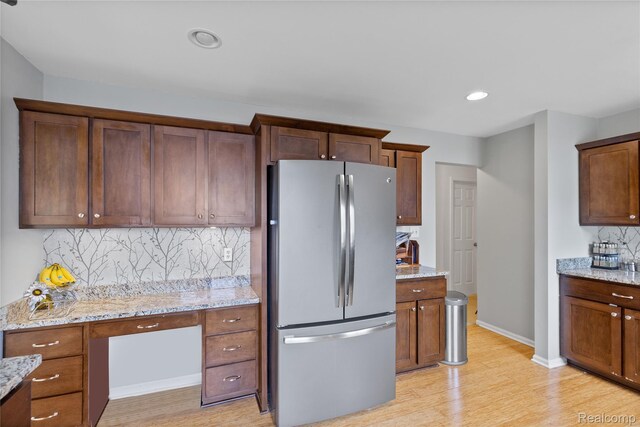 2375 Mulberry Sq Unit 69, Bloomfield Hills, MI 48302 - kitchen with freestanding refrigerator, light wood-style floors, light stone counters, tasteful backsplash, and recessed lighting