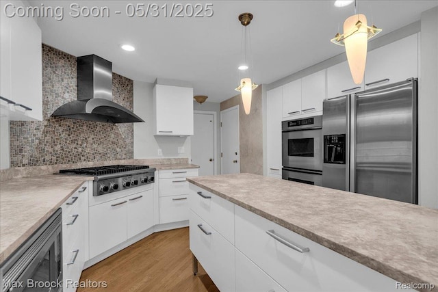 2222 Garland St, Sylvan Lake, MI 48320 - kitchen with wall chimney exhaust hood, stainless steel appliances, white cabinets, decorative light fixtures, and recessed lighting