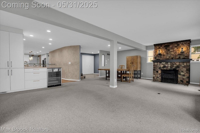 2222 Garland St, Sylvan Lake, MI 48320 - living area with beverage cooler, a fireplace, recessed lighting, baseboards, and light colored carpet