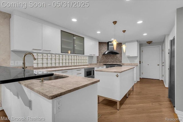 2222 Garland St, Sylvan Lake, MI 48320 - kitchen featuring wall chimney exhaust hood, stainless steel microwave, decorative backsplash, white cabinetry, and range