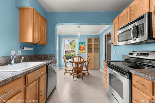 3135 Raymond Ave, Dearborn, MI 48124 - kitchen featuring stainless steel appliances, a sink, baseboards, and dark countertops