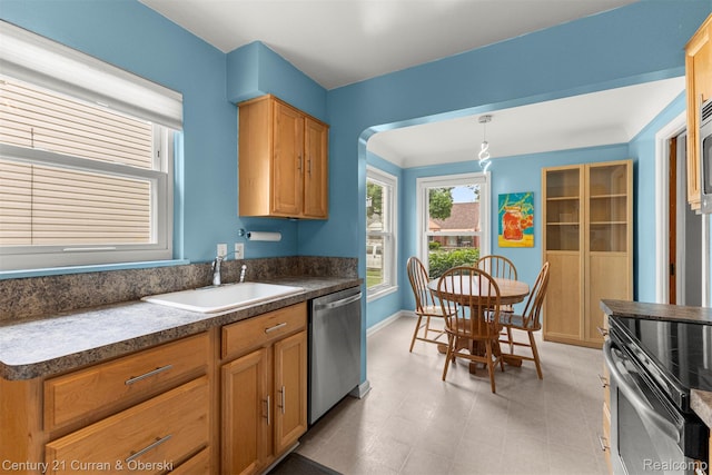 3135 Raymond Ave, Dearborn, MI 48124 - kitchen with a sink, appliances with stainless steel finishes, dark countertops, baseboards, and hanging light fixtures