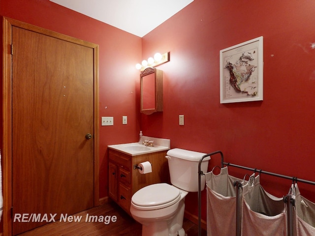 5475 George St, Saginaw, MI 48603 - bathroom with wood finished floors, vanity, toilet, and baseboards
