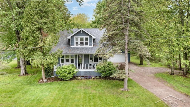 1784 S Badour Rd, Midland, MI 48640 - view of front of house featuring driveway, a porch, a front yard, and roof with shingles