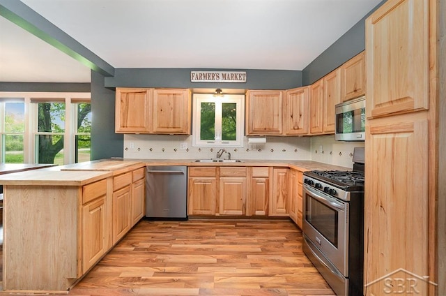 1784 S Badour Rd, Midland, MI 48640 - kitchen featuring stainless steel appliances, light brown cabinetry, light wood finished floors, and a peninsula