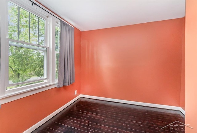 1784 S Badour Rd, Midland, MI 48640 - empty room featuring healthy amount of natural light, dark wood-style floors, and baseboards