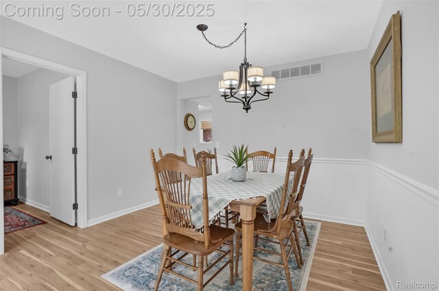 9587 Harmon Ln, South Lyon, MI 48178 - dining area with a chandelier, light wood-style flooring, and baseboards