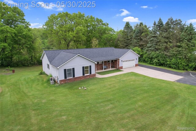 9587 Harmon Ln, South Lyon, MI 48178 - ranch-style house featuring concrete driveway, an attached garage, roof with shingles, a front lawn, and a porch