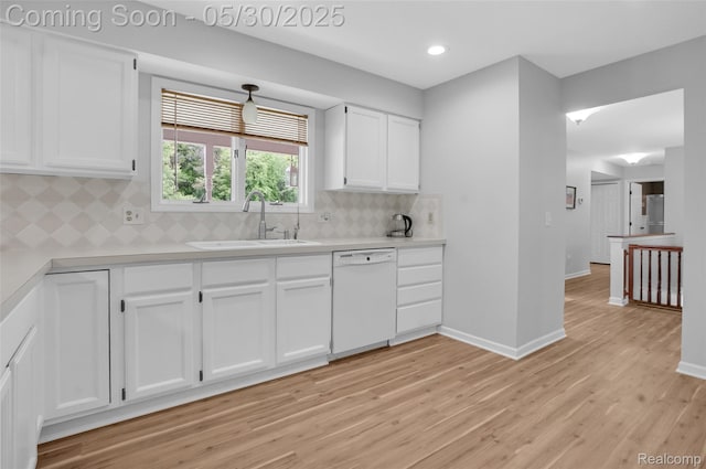 9587 Harmon Ln, South Lyon, MI 48178 - kitchen with dishwasher, a sink, white cabinets, light wood-style floors, and light countertops