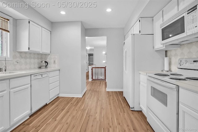 9587 Harmon Ln, South Lyon, MI 48178 - kitchen with white appliances, light countertops, light wood-style floors, decorative backsplash, and recessed lighting