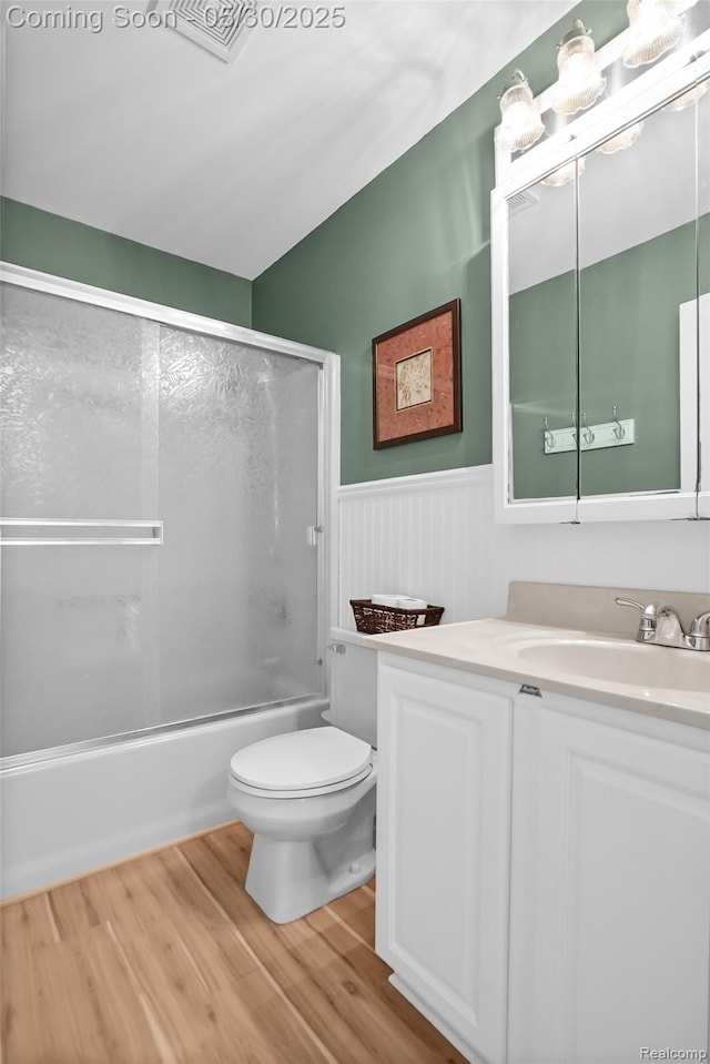 9587 Harmon Ln, South Lyon, MI 48178 - full bathroom with toilet, wood finished floors, vanity, a wainscoted wall, and shower / bath combination with glass door