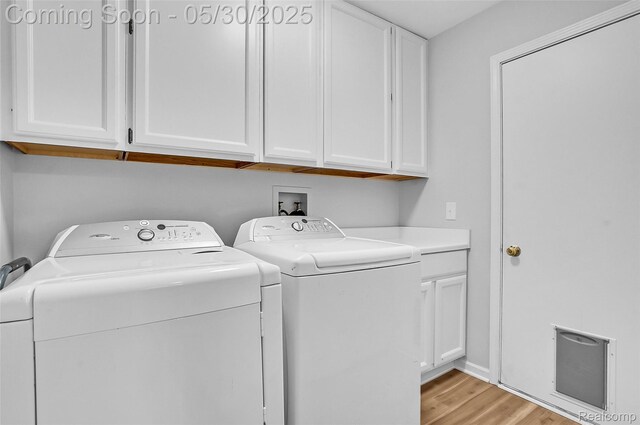 9587 Harmon Ln, South Lyon, MI 48178 - laundry room featuring washing machine and clothes dryer, light wood-type flooring, and cabinet space