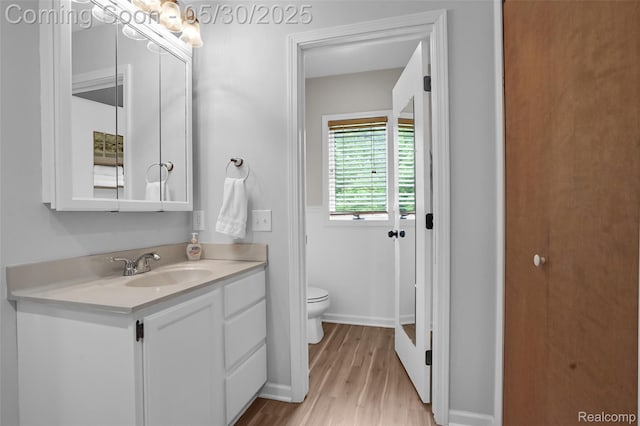 9587 Harmon Ln, South Lyon, MI 48178 - bathroom with toilet, vanity, wood finished floors, and baseboards
