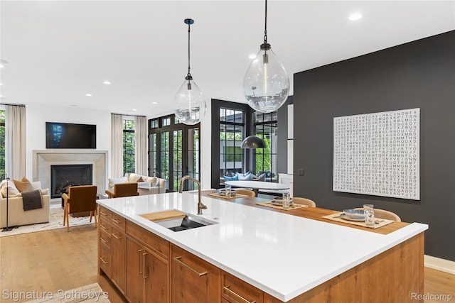 608 Stanley Blvd, Birmingham, MI 48009 - kitchen with a sink, open floor plan, light wood finished floors, a fireplace, and light countertops