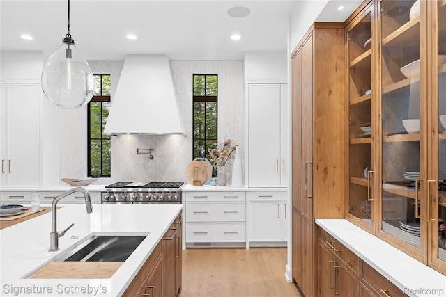 608 Stanley Blvd, Birmingham, MI 48009 - kitchen with custom exhaust hood, brown cabinetry, light countertops, and recessed lighting