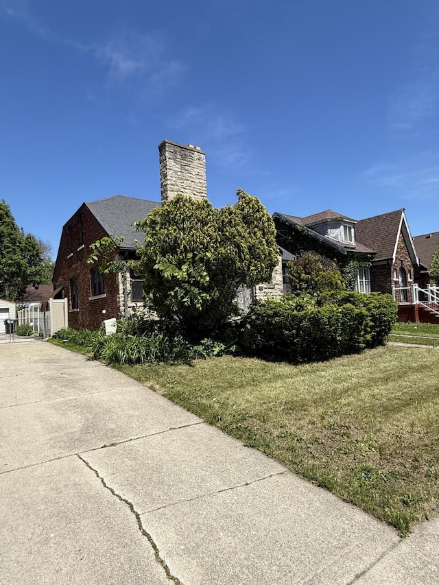 9142 Yorkshire Rd, Detroit, MI 48224 - view of home's exterior featuring a yard, a chimney, and roof with shingles