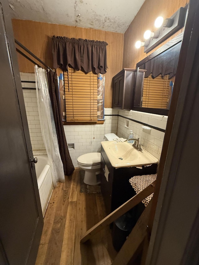 9142 Yorkshire Rd, Detroit, MI 48224 - full bath featuring wood-type flooring, toilet, vanity, shower / bath combo with shower curtain, and tile walls