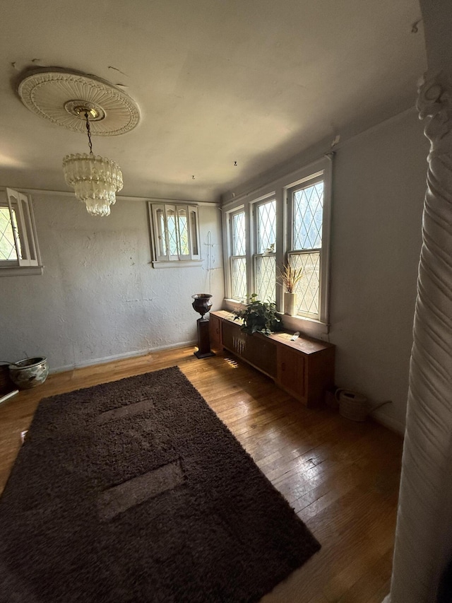9142 Yorkshire Rd, Detroit, MI 48224 - empty room featuring wood finished floors, plenty of natural light, and a chandelier