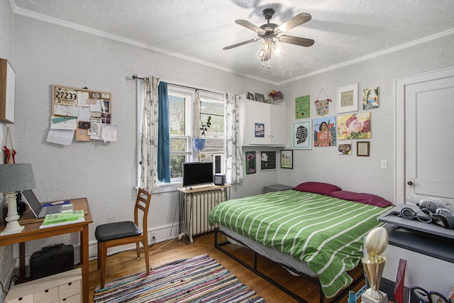 2313 S Westnedge Ave, Kalamazoo, MI 49008 - bedroom featuring radiator heating unit, wood finished floors, ornamental molding, a textured wall, and a textured ceiling