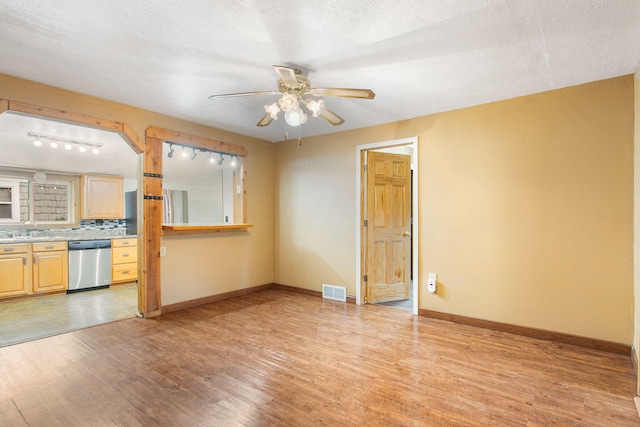 222 Oak St, South Haven, MI 49090 - unfurnished living room with a ceiling fan, light wood-style flooring, and baseboards