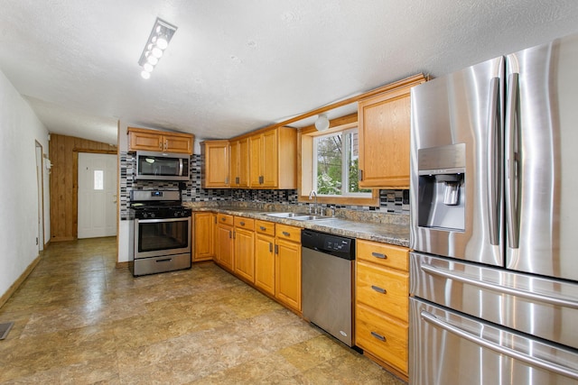 222 Oak St, South Haven, MI 49090 - kitchen featuring appliances with stainless steel finishes, a sink, tasteful backsplash, and dark countertops