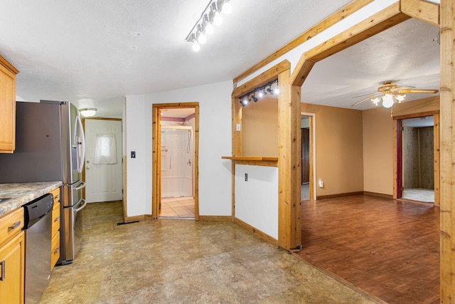 222 Oak St, South Haven, MI 49090 - kitchen featuring appliances with stainless steel finishes, a ceiling fan, baseboards, light countertops, and a textured ceiling
