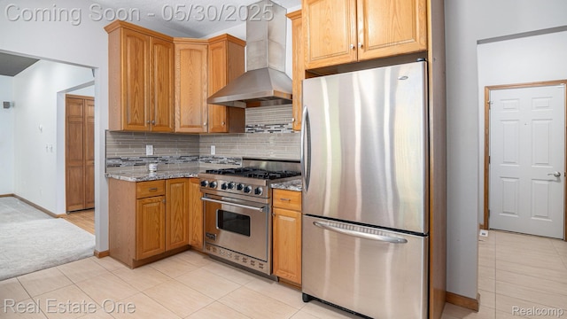 5305 Fern Dr, Fenton, MI 48430 - kitchen with stainless steel appliances, wall chimney range hood, stone counters, tasteful backsplash, and baseboards