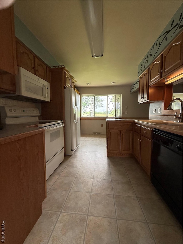 7145 Morrish Rd, Swartz Creek, MI 48473 - kitchen with white appliances, a peninsula, light tile patterned floors, and a sink