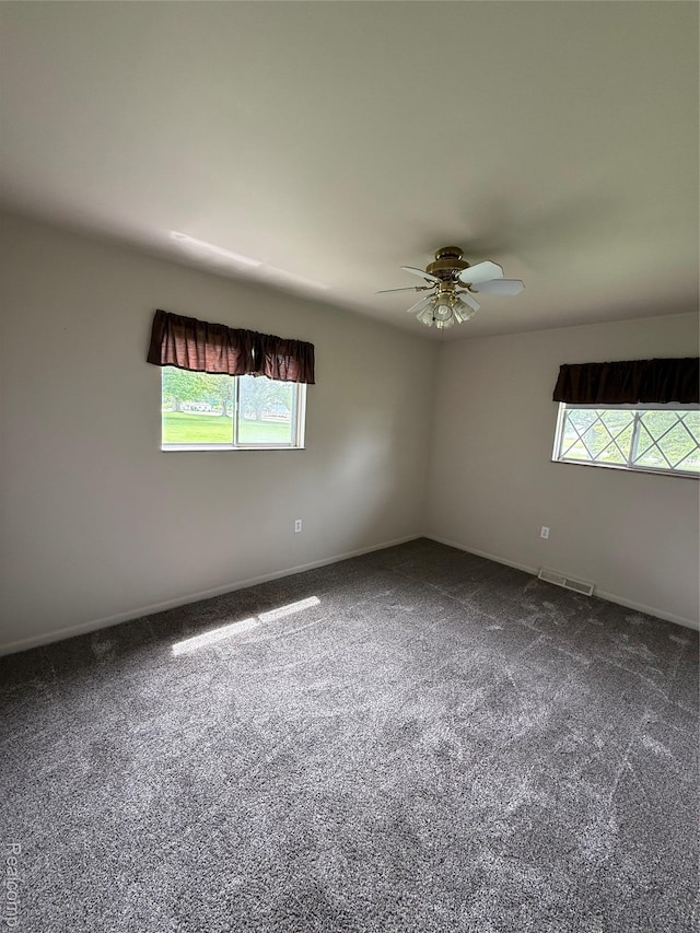 7145 Morrish Rd, Swartz Creek, MI 48473 - empty room featuring plenty of natural light, dark colored carpet, and a ceiling fan