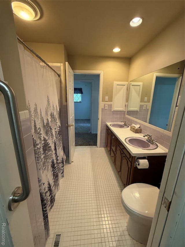 7145 Morrish Rd, Swartz Creek, MI 48473 - bathroom featuring tile walls, toilet, tile patterned floors, double vanity, and a wainscoted wall