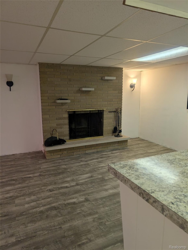 7145 Morrish Rd, Swartz Creek, MI 48473 - unfurnished living room featuring a paneled ceiling, a brick fireplace, and wood finished floors
