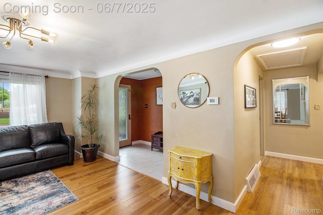 305 Garland St, Davison, MI 48423 - living room with arched walkways, light wood-style flooring, and baseboards