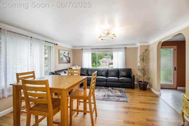 305 Garland St, Davison, MI 48423 - dining area featuring arched walkways, light wood-style flooring, baseboards, and a chandelier