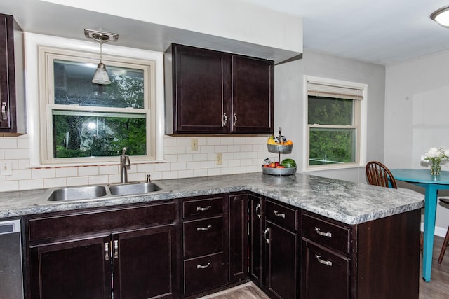 1419 Vassar Dr, Kalamazoo, MI 49001 - kitchen featuring a sink, a peninsula, stainless steel dishwasher, and tasteful backsplash