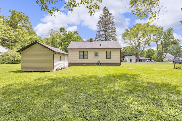 870 Bryant Ave, Jackson, MI 49202 - back of house featuring a chimney and a yard
