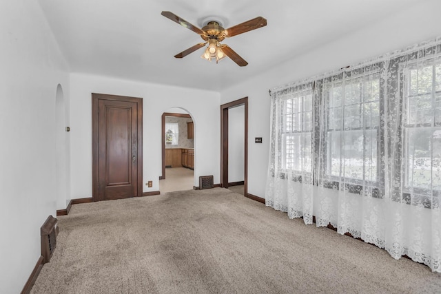 870 Bryant Ave, Jackson, MI 49202 - unfurnished room featuring arched walkways, ceiling fan, carpet floors, and baseboards